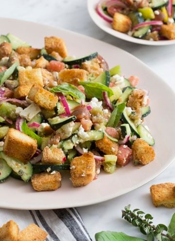 A photo of a panzanella salad on a serving plate.