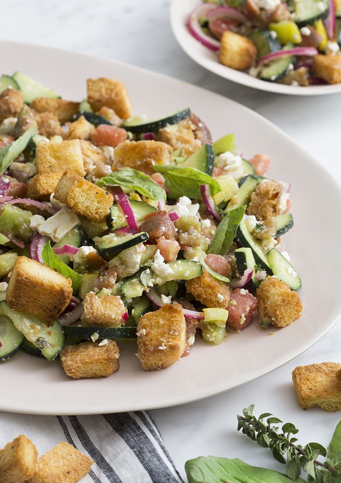 A photo of a panzanella salad on a serving plate.