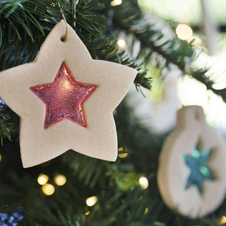 Stained glass cookies hanging on a Christmas tree.