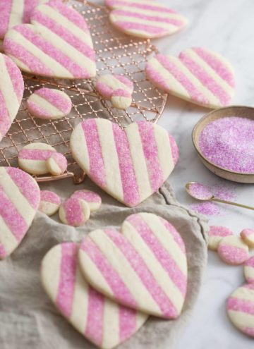 A photo showing a group of striped pink and white Valentine's Day Heart Cookies on a white marble surface