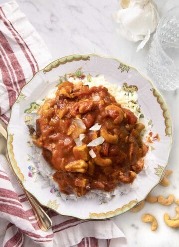 Butter chicken on a plate garnished with coconut.