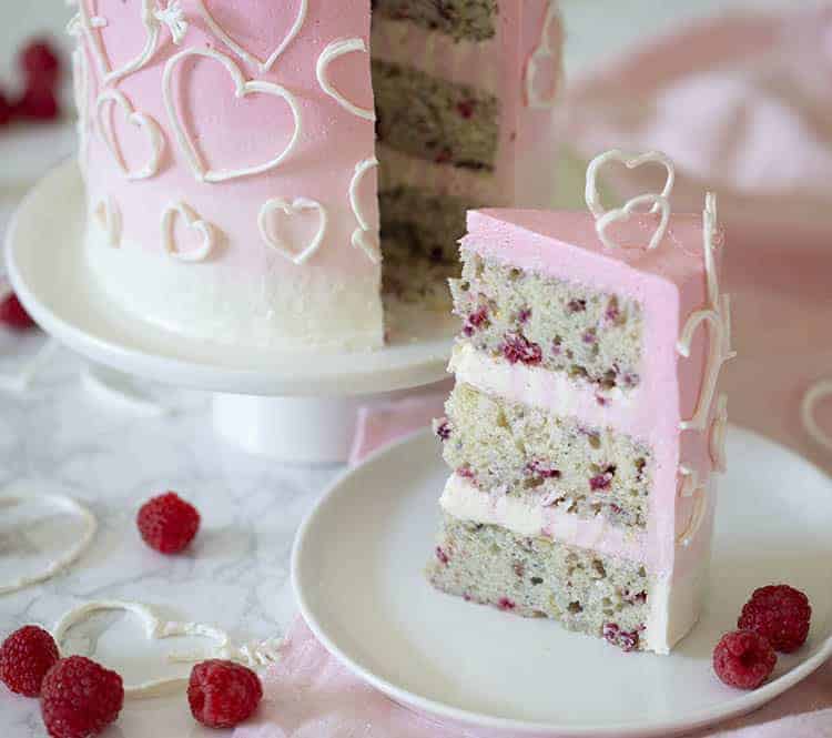 A piece of Valentines raspberry heart cake on a white plate.