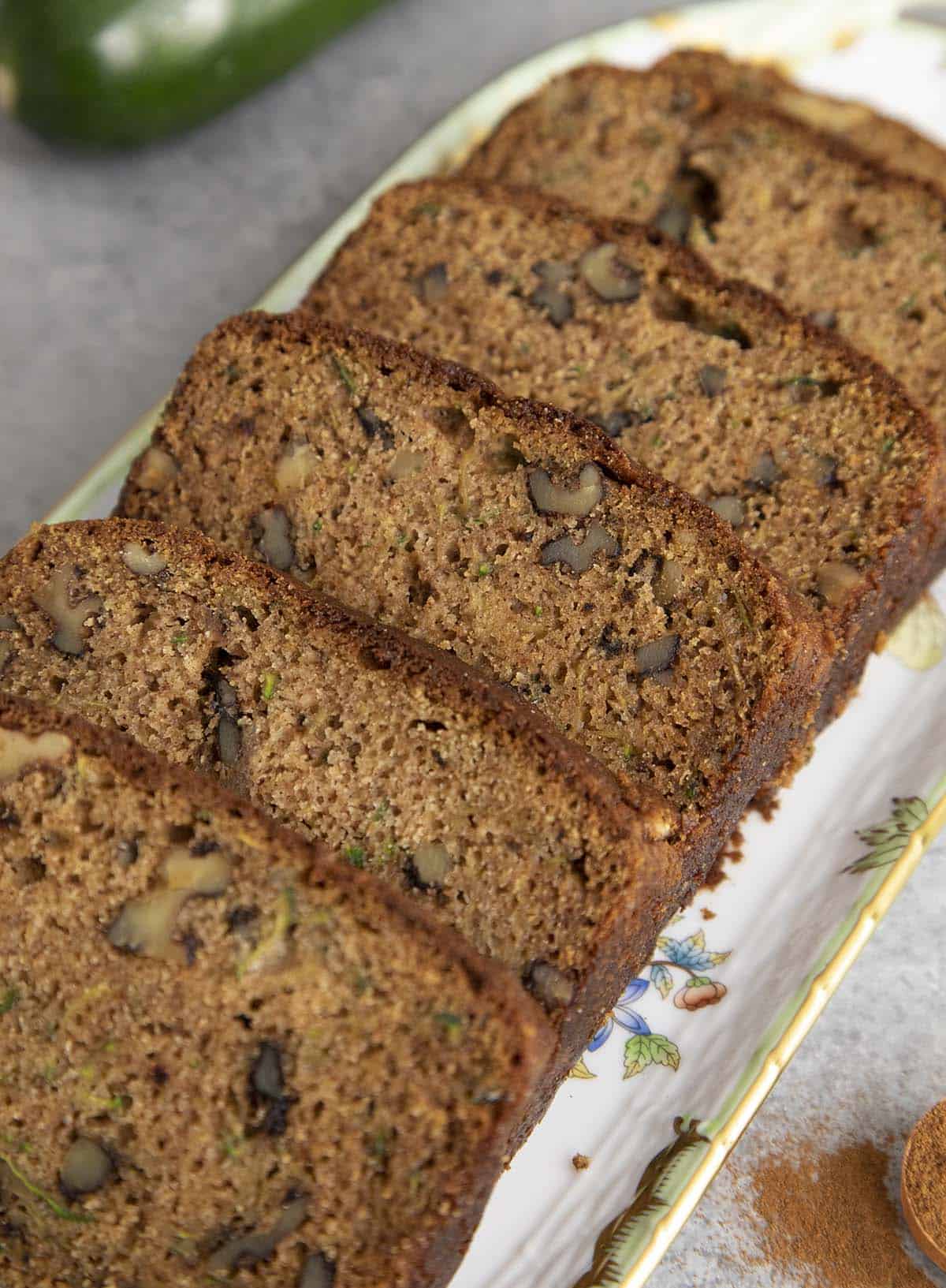 Slices of zucchini bread on a porcelain serving tray.