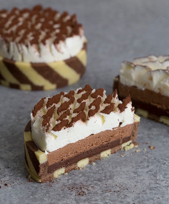 A photo of a chocolate tart cut in half showinf the three different colored layers inside.