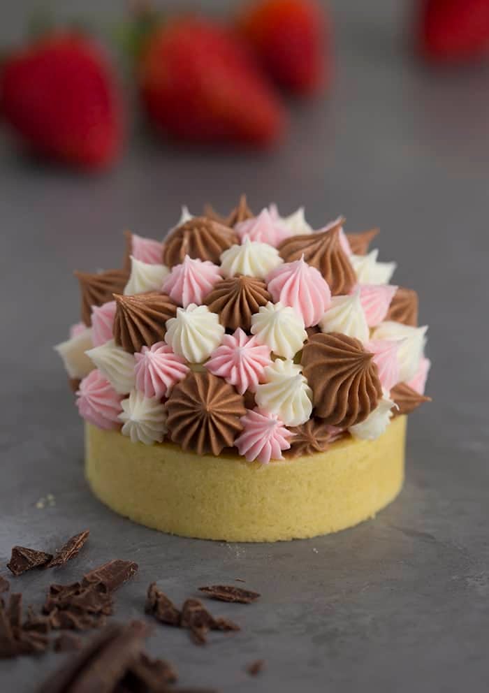 A photo of a Neapolitan tart with different sized dollops of Swiss meringue buttercream piped on top.