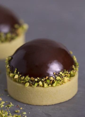 A pistachio tart topped with a chocolate dome