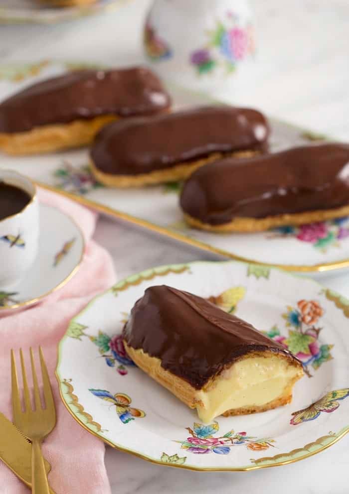A photo of a chocolate eclair cut to expose the custard filling