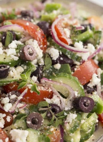 A closeup shot of Greek Salad with tomatoes cucumber and feta.
