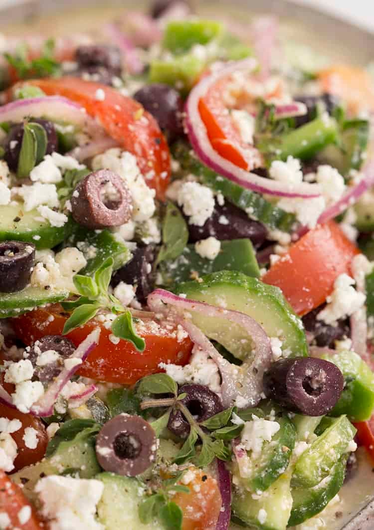 A closeup shot of Greek Salad with tomatoes cucumber and feta.