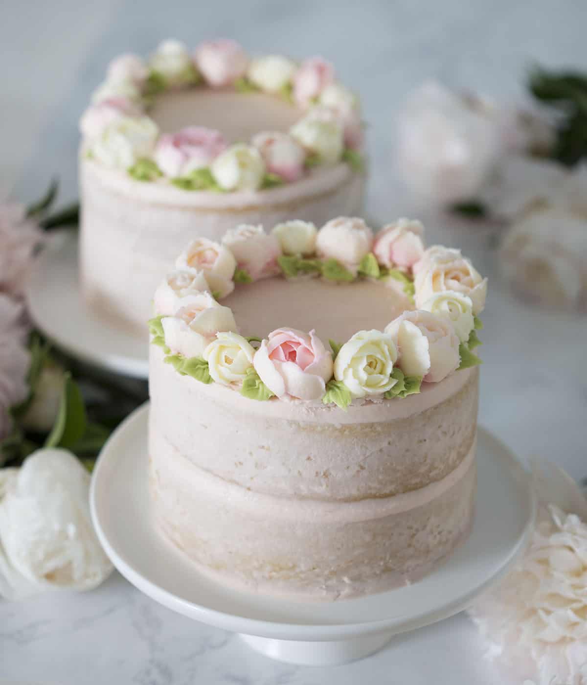 Two smash cakes with buttercream frosting roses.