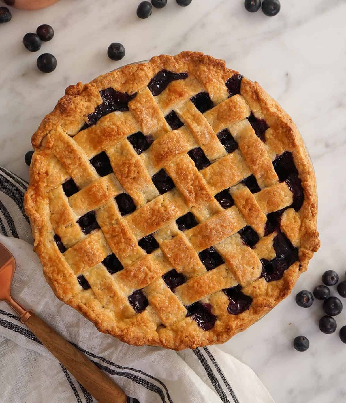 An overhead view of a blueberry pie with a lattice top.