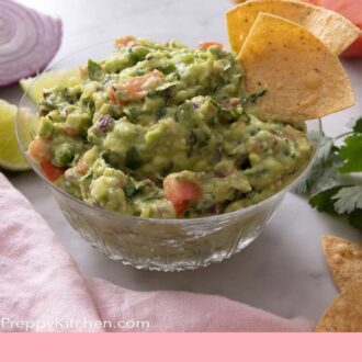 Pinterest graphic of a bowl of guacamole with tortilla chips dipped inside.
