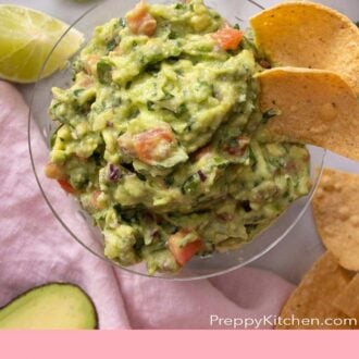 Pinterest graphic of an overhead view of a bowl of guacamole with tortilla chips. Chips and limes surrounding the bowl.