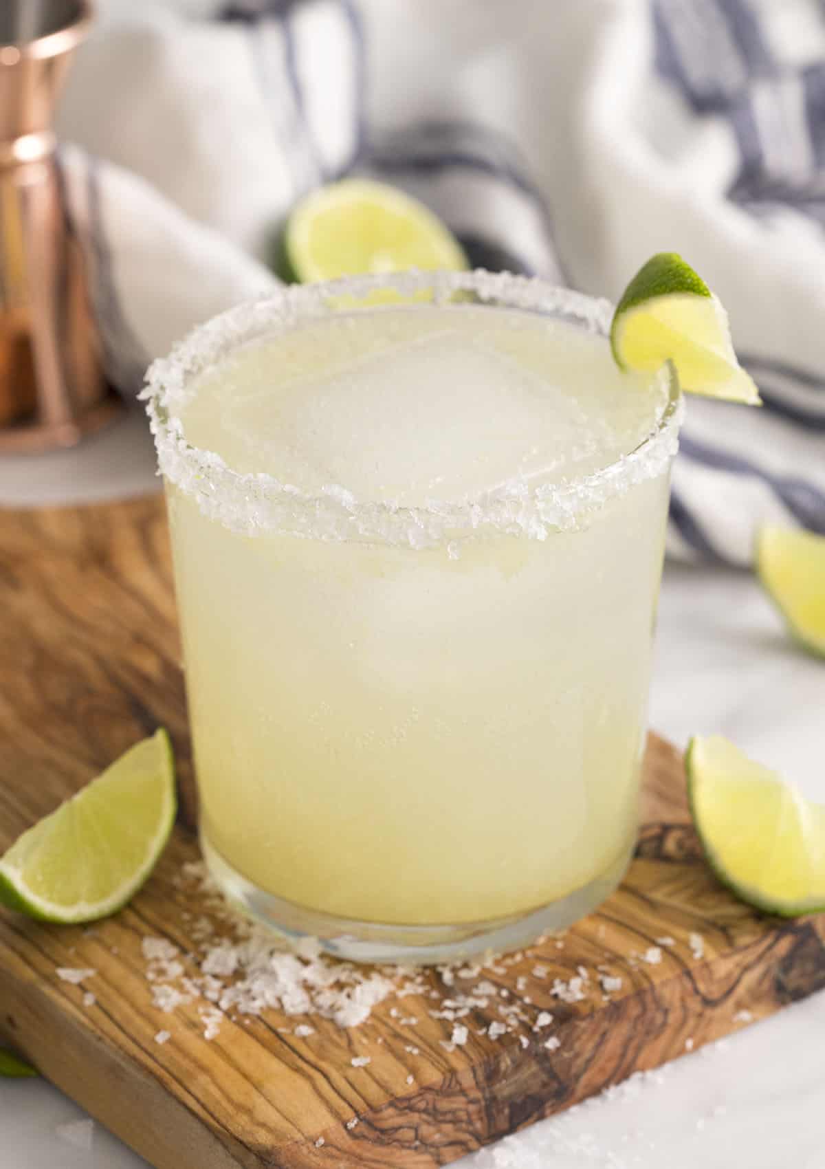 A from-scratch margarita in a tumbler garnished with a lime wedge.