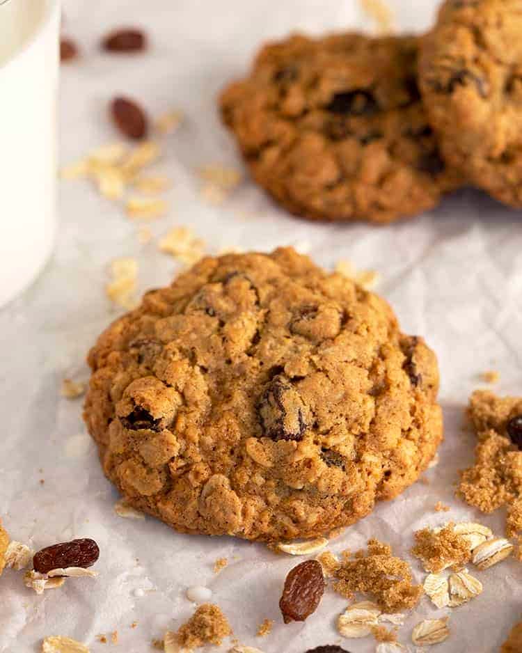 A close up of a oatmeal raisin cookie on baking parchment