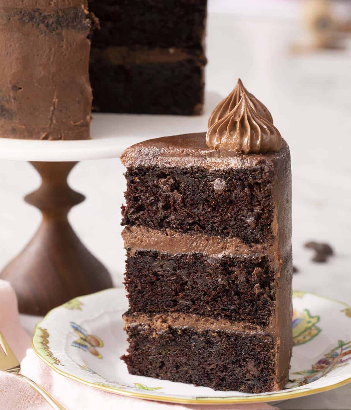 A big piece of three layer chocolate zucchini cake on a plate.