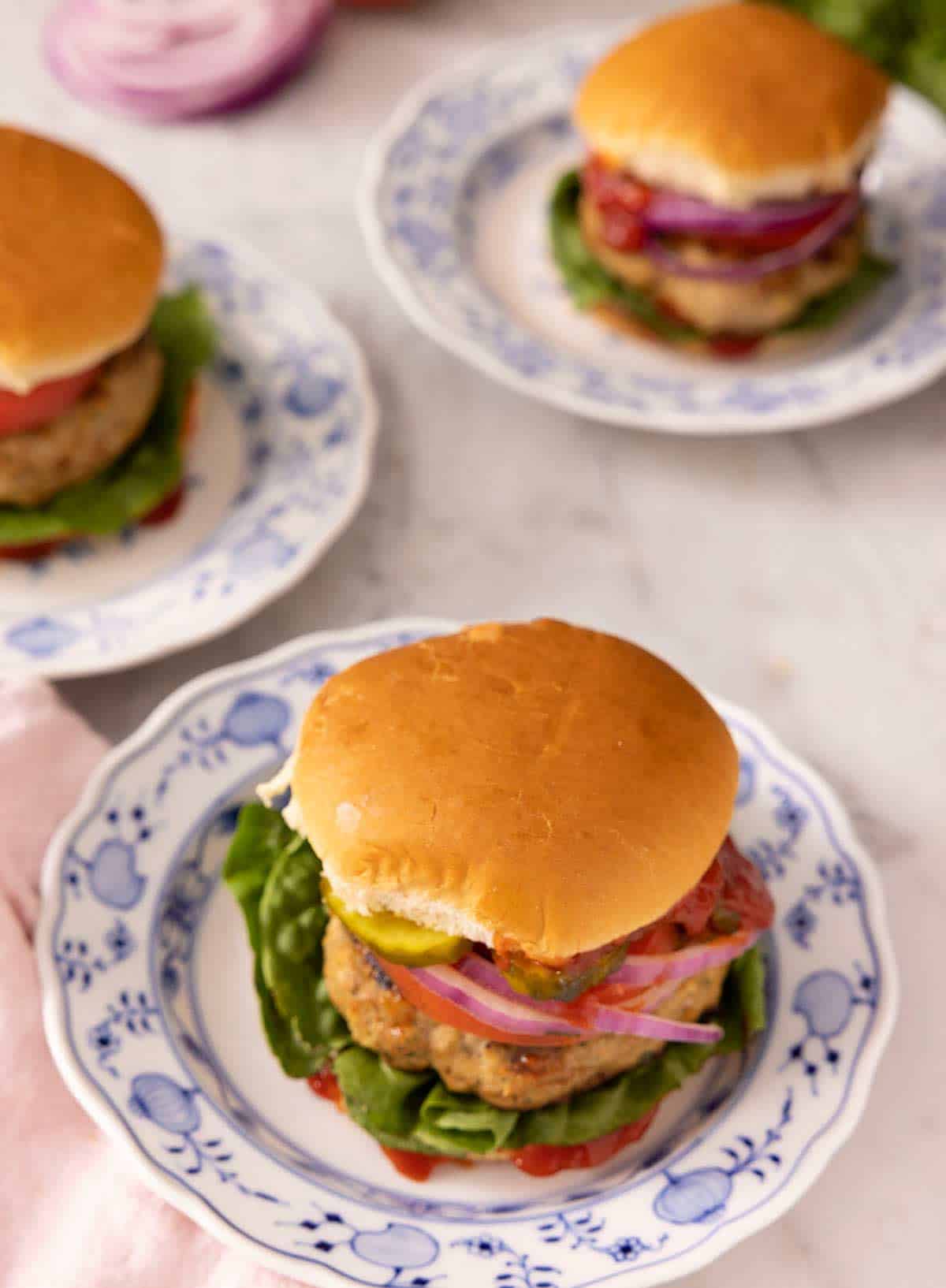 Three turkey burgers on blue plates