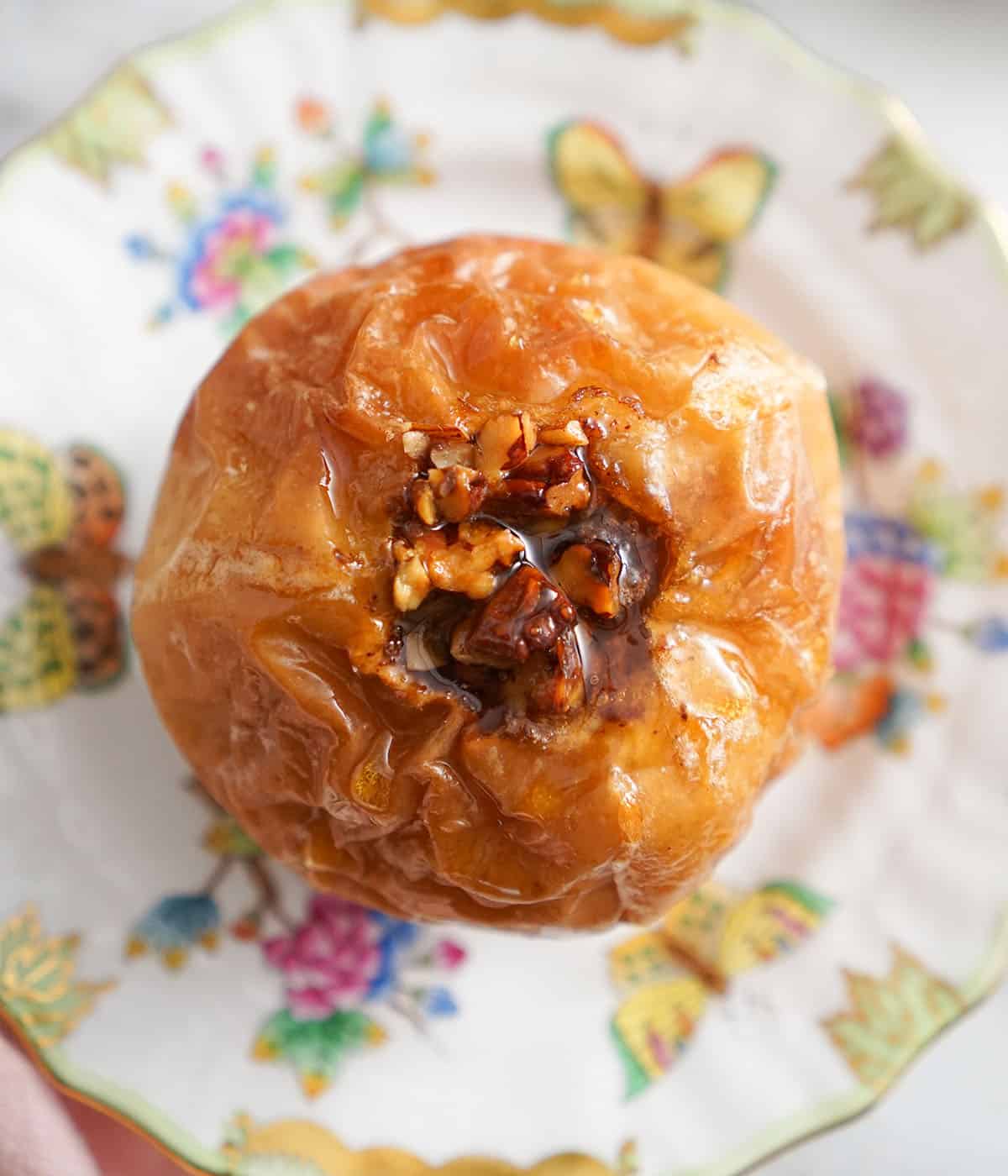 An overhead view of a baked apple on a plate.