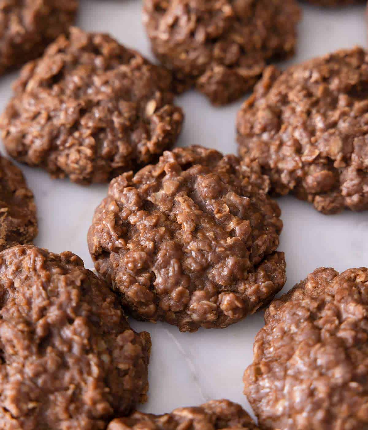A close up of no-bake cookies in a single layer on a marble surface.