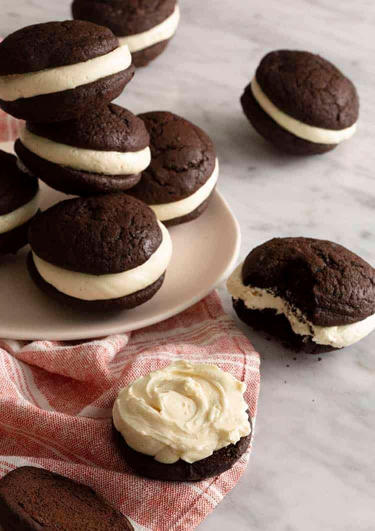 A group of whoopie pies on a white marble table.