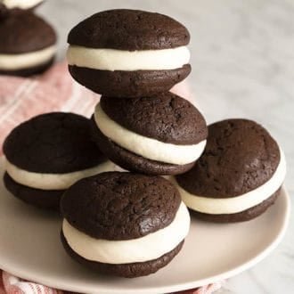 Chocolate whoopie pies on a soft pink plate.