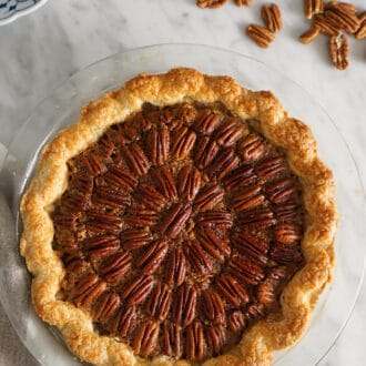 Pinterest graphic of a pecan pie next to some pecans on a table.