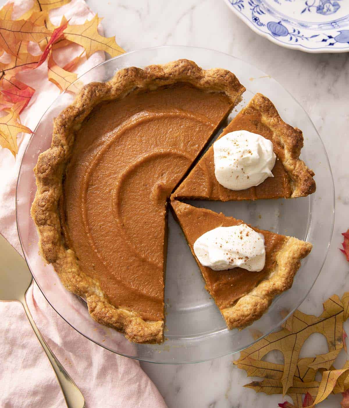 Pinterest graphic of a sweet potato pie in a glass dish with 2 pieces cut out.