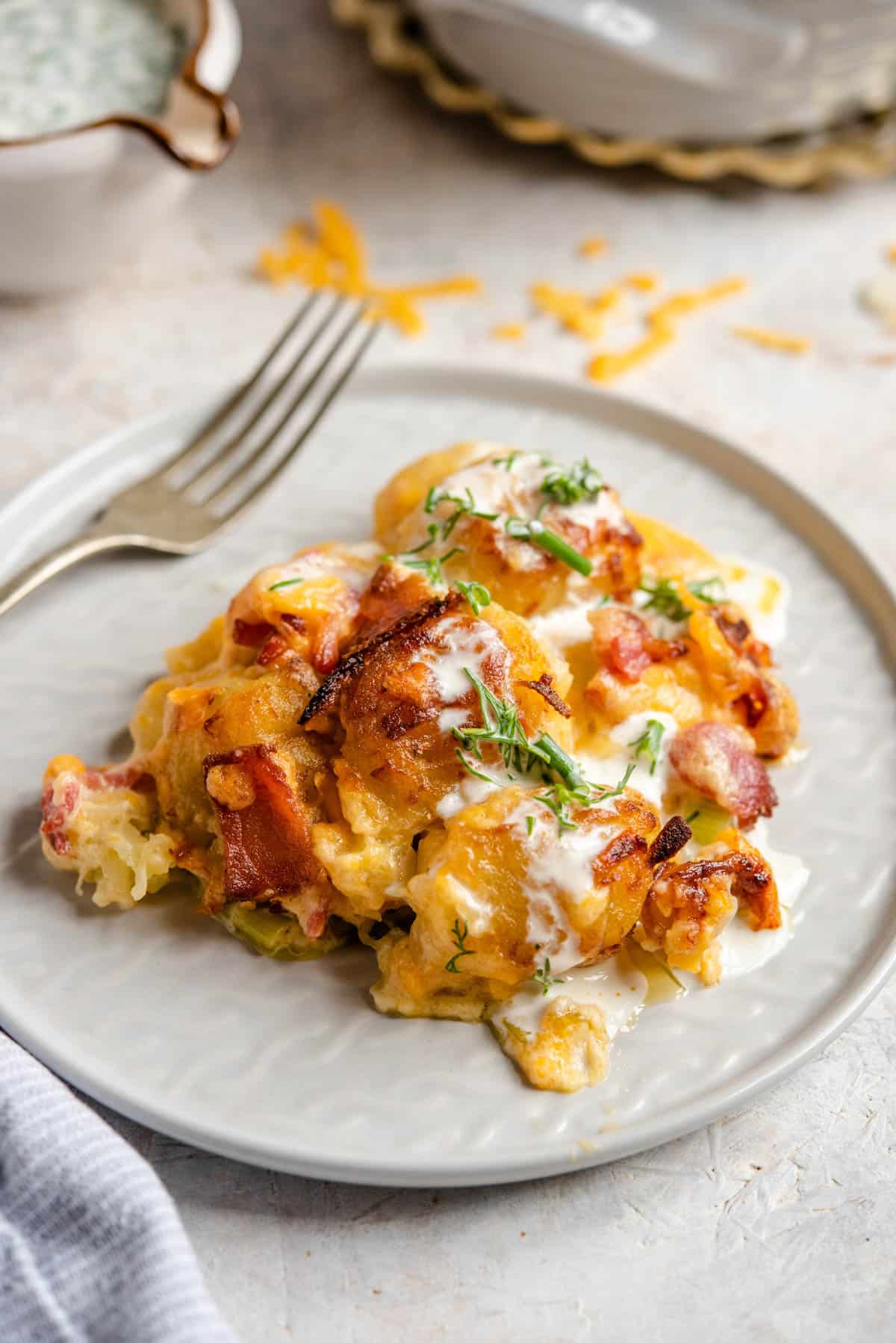 A side shot of tater tot casserole on a plate with a fork