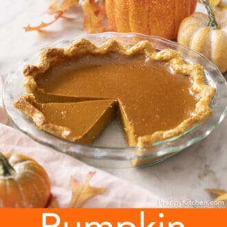 Pinterest graphic of pumpkin pie in a glass pie dish with autumn decorations behind it.