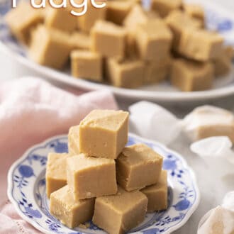 Pinterest graphic of peanut butter fudge pieces on a blue and white plate with a platter in the background.
