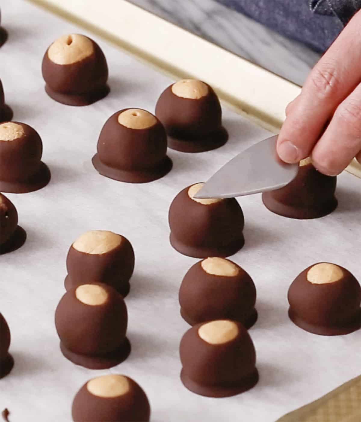 Buckeyes getting smoothed with a small knife.