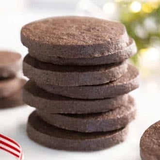 A stack of round chocolate sugar cookies on a marble table.