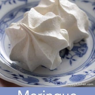 Pinterest graphic showing two meringue cookies on a blue and white plate.