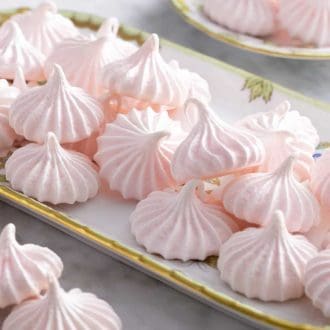 Pinterest graphic showing meringue kisses on a platter with more around it.