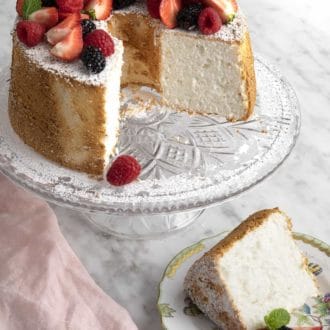 Pinterest graphic of an angel food cake on a glass cake stand with a slice cut out and plated.