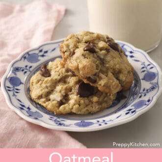 Two Oatmeal Chocolate Chip Cookies next to a glass of milk.