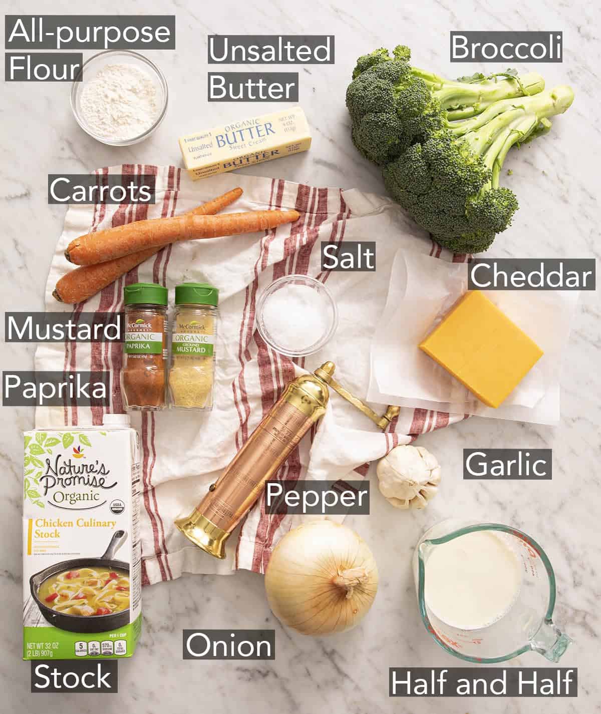 Ingredients for making broccoli cheese soup on a marble counter.