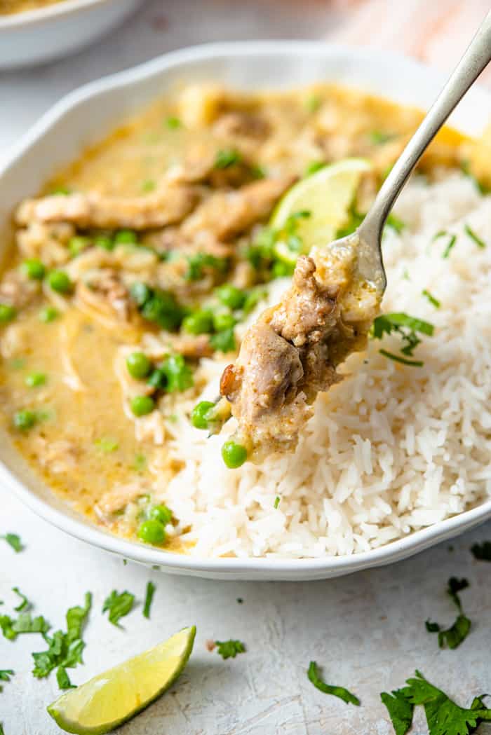 A close up of a some chicken curry on a fork