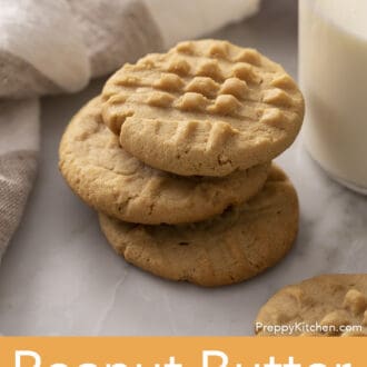 A stack of three peanut butter cookies on a counter.
