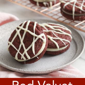 Pinterest graphic of two red velvet cookies on a plate, topped with white chocolate drizzle.