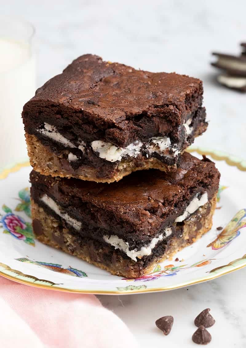 Two slutty brownies stacked on top of each other on a plate.
