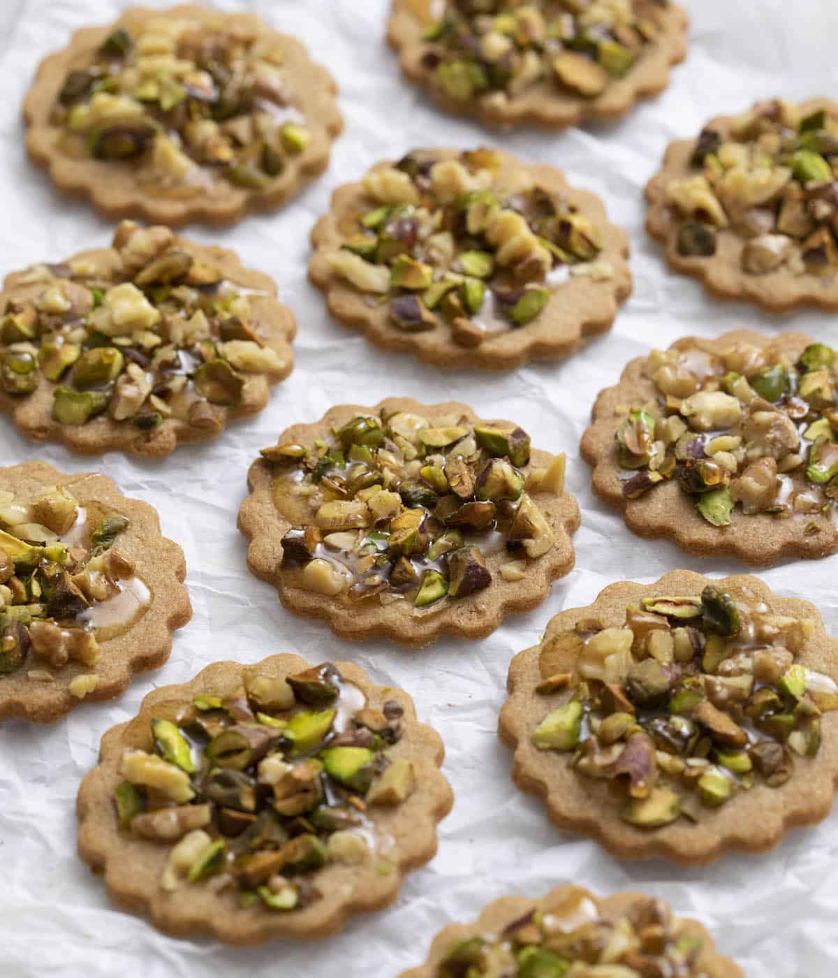 A group of baklava cookies on parchment paper.