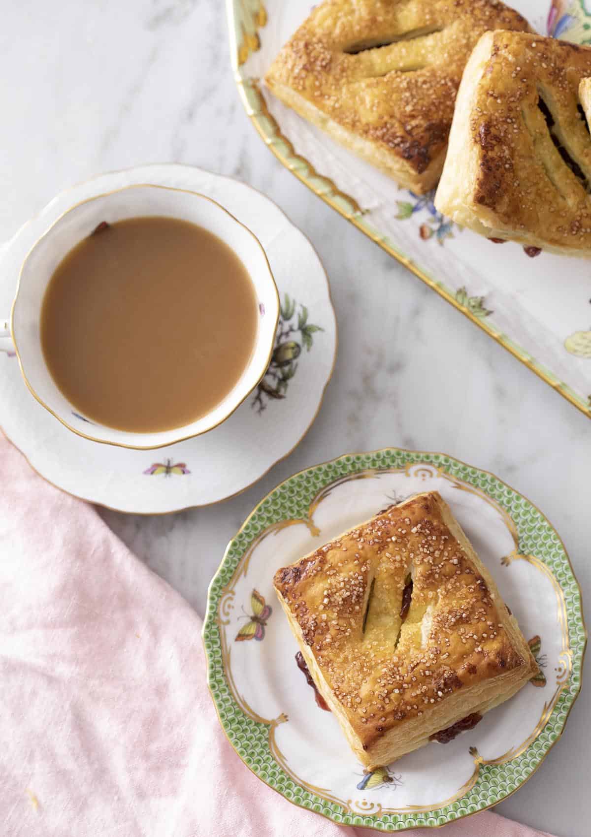 Pastelitos on a porcelain serving set with coffee.