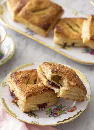 pastelitos de guayaba on a place next to a cup of coffee.