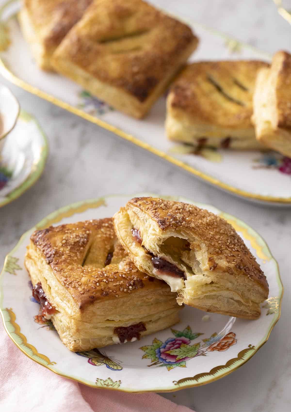 pastelitos de guayaba on a place next to a cup of coffee.