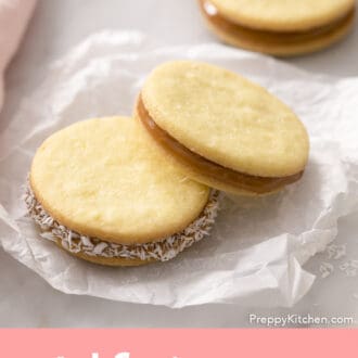 Pinterest graphic of two alfajores on a piece of parchment paper.