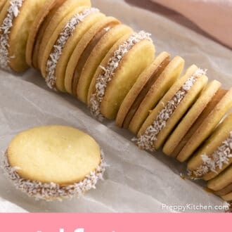 Pinterest graphic of alfajores coookies arranger on white parchment paper.