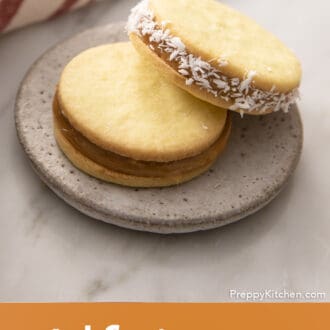 Pinterest graphic of two alfajores on a plate, one with coconut flakes.