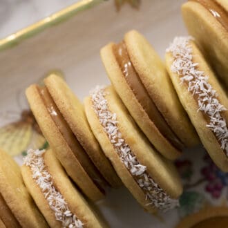 Pinterest graphic of alfahores with alternating decorations on a tray.