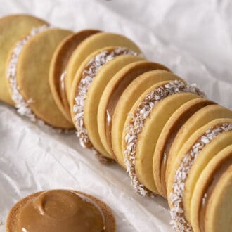 Pinterest graphic of a group of alfahores cookies on parchment.